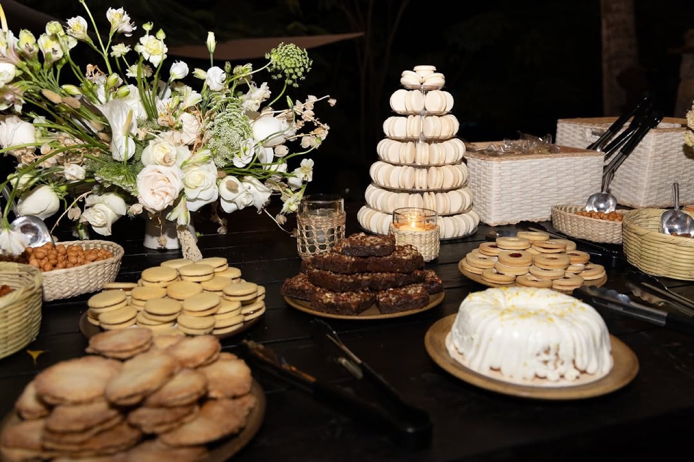 Mesa de postres con torre de macarons y flores